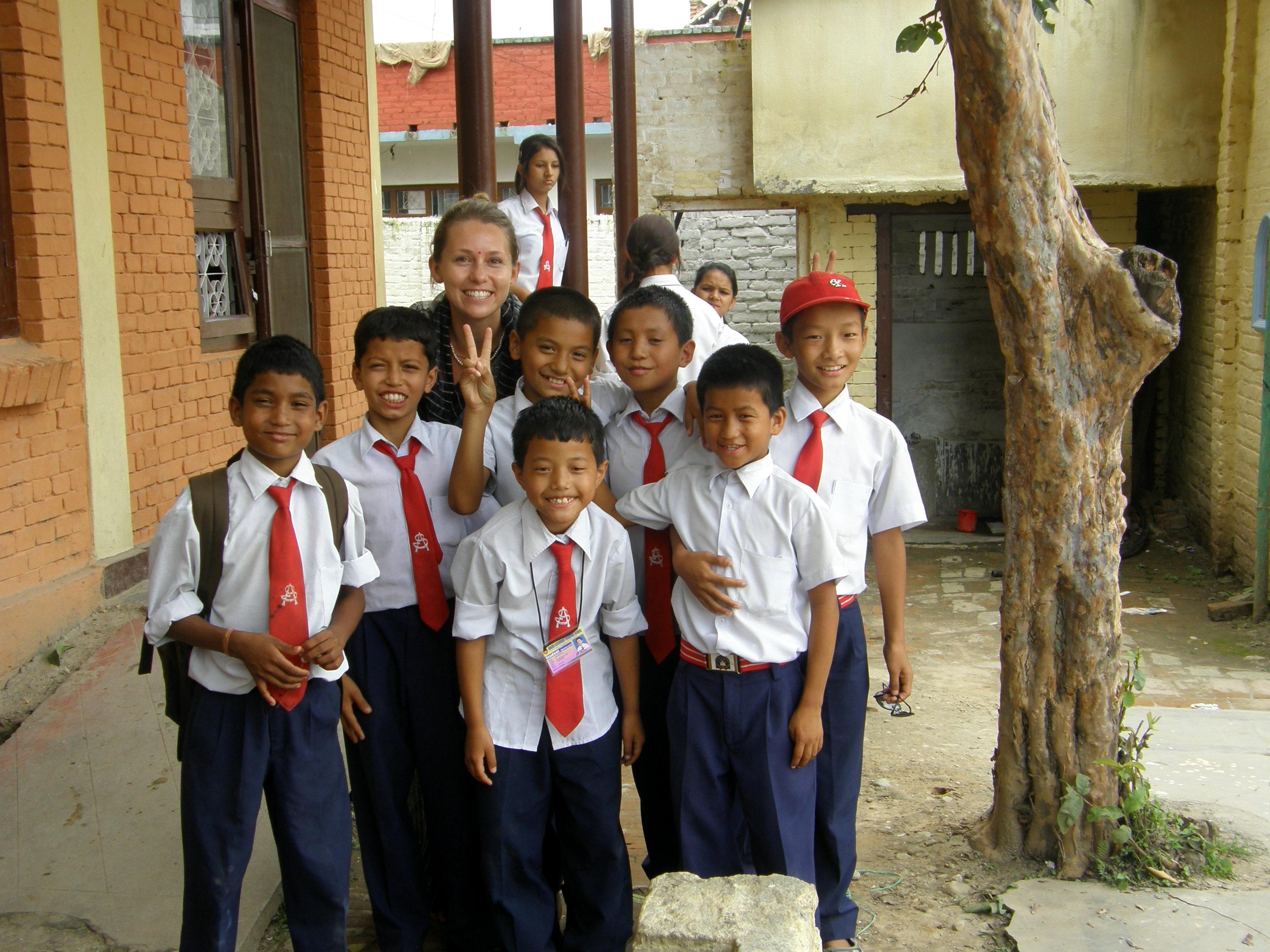 Volunteer teaching in Nepal poses for a photo with her students A group photo of a Projects Abroad volunteer with her students at her volunteer teaching placement in Nepal